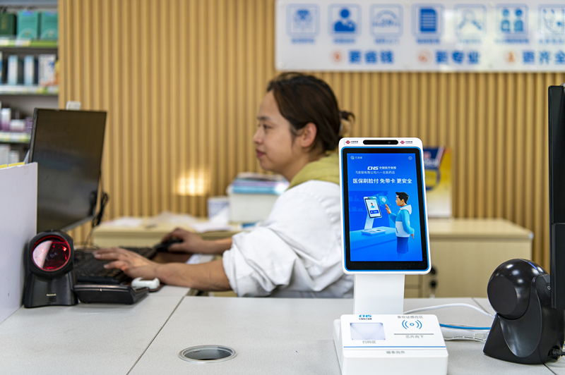 2024年4月10日，浙江金華市區(qū)一家民眾大藥房柜臺(tái)上設(shè)置著醫(yī)?！八⒛樦Ц丁睓C(jī)器，群眾看病更加便利。